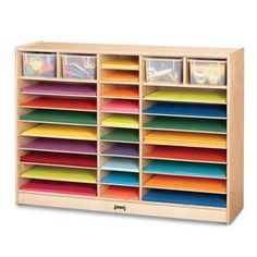 a wooden storage unit filled with lots of different colored cards and folders on it