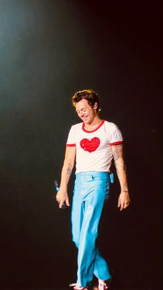 a man in white shirt and blue pants on a skateboard with red heart t - shirt