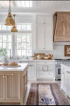 a kitchen with white cabinets and an area rug