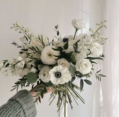 a person holding a bouquet of white flowers