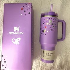 the purple travel mug is next to its box