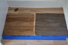 wood flooring samples with blue tape on the top and bottom edge in an unfinished room