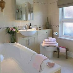 a bath room with a tub a sink and a mirror on the wall next to a window