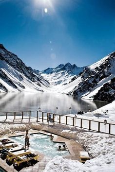 a hot tub surrounded by snow covered mountains