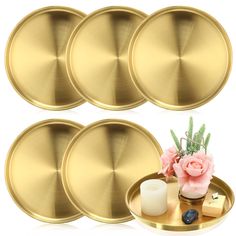 six gold plates with flowers and candles on them