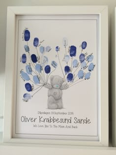 two framed pictures with blue flowers and a teddy bear in the middle one is for someone's birth