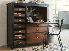 an old wooden cabinet with many drawers in the middle and a chair next to it