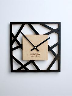 a square wooden clock with black and white geometric design