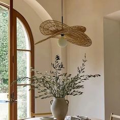 a dining room table with a vase on top of it next to an open window