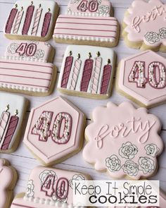 decorated cookies with pink frosting and white icing are arranged in the shape of numbers