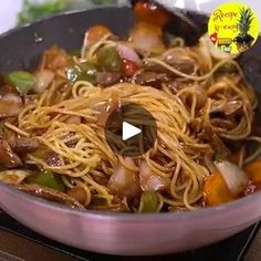 a pan filled with noodles and vegetables on top of a stove