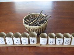 a wooden table topped with lots of cups filled with different types of pencils and numbers