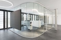 an office with glass walls and white desks