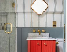 a bathroom with a sink, mirror and red cabinet