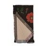 three napkins with flowers on them are folded in black and white paper, one has a red flower