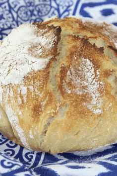 a loaf of bread sitting on top of a blue and white plate covered in powdered sugar