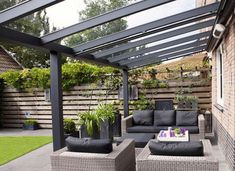 an outdoor living area with black furniture and plants