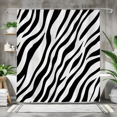 a shower curtain with zebra print on it in a bathroom next to potted plants