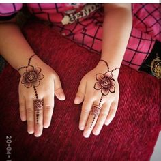 two hands with henna tattoos on them