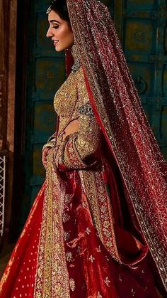 a woman in a red and gold bridal gown, with her veil pulled back