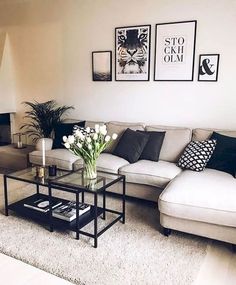 a living room with couches, tables and pictures on the wall above them in black and white