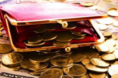 a red purse sitting on top of a pile of money