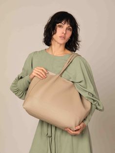 This elegant, handmade large tote bag enhances your look with its modern, appealing design. It offers ample space and is lightweight, perfect for daily essentials. Crafted by hand in Italy, this bag is made entirely of 100% natural, genuine leather. It features a small pouch inside with a zipper and is designed without any additional lining fabrics, offering a natural leather interior. The bag showcases expert craftsmanship, top-notch quality, and is made from soft yet durable genuine leather. F Large Modern Beige Shoulder Bag, Modern Large Beige Shoulder Bag, Large Modern Beige Bag, Large Elegant Beige Shoulder Bag, Large Beige Satchel, Large Beige Shoulder Bag With Removable Pouch, Everyday Large Capacity Square Hobo Bag, Trendy Neutral Tote Shoulder Bag, Chic Taupe Bucket Bag For Everyday