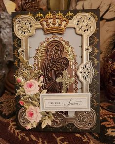 an ornate card with gold foil and flowers on it, featuring the image of mary