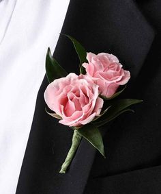 two pink flowers are placed on the lapel of a black suit