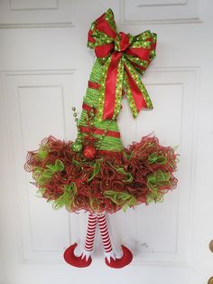 a door hanger decorated with red and green christmas wreaths, stockings and socks