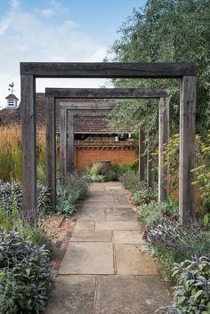 an outdoor garden with stone walkway and wooden arbor