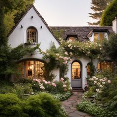 a white house surrounded by greenery and flowers