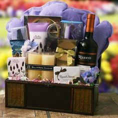 a gift basket with wine, candles and other items