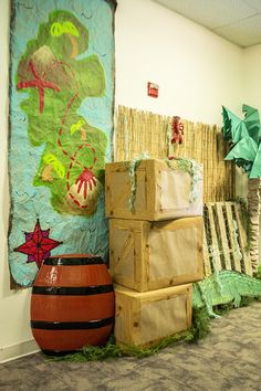 several boxes are stacked next to each other in front of a wall with paintings on it