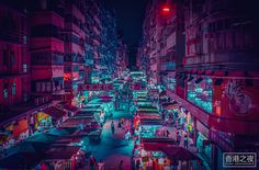 an aerial view of a city street at night with neon lights and people walking on the sidewalk