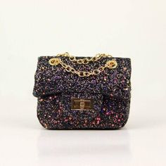 Description Sparkle with every step carrying the Coco Glitter Purse! This mini purse dazzles in a rainbow of glittery finishes, available in five stunning shades: white, rainbow, purple, black, and peach. Its versatile chain strap can be adjusted for wear as a crossbody or over the shoulder, making it a perfect blend of function and flair for any ensemble. Trendy Iridescent Party Bag, Trendy Glitter Bags For Gifts, Trendy Glitter Bags As Gifts, Unicorn Plushies, Glitter Purse, Crystal Purse, Kids Purse, Pearl Clutch, Rainbow Pearl