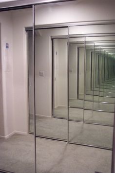 an empty room with mirrored walls and doors