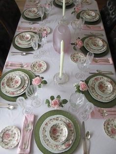 the table is set with pink and green china