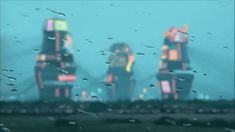 rain drops on the windshield of a car as people stand in front of an amusement park