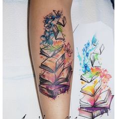 a tattoo on the leg of a woman with books and flowers around her arm,