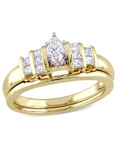 a yellow gold wedding ring set with two princess cut diamonds on each band and an oval shaped diamond in the center