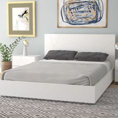 a white bed sitting in a bedroom on top of a rug