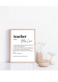 a teacher definition print on a shelf next to a vase with pencils