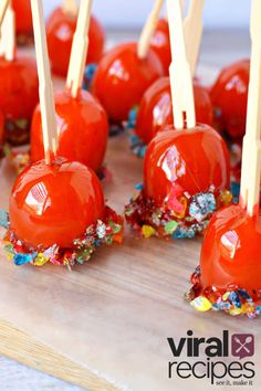 candy apples with toothpicks and sprinkles on a cutting board