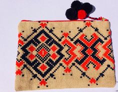 a small purse with a red and black design on it