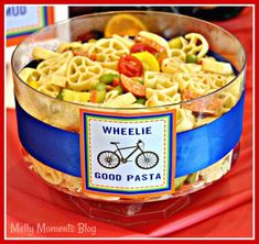 a bowl filled with pasta and veggies on top of a red table cloth