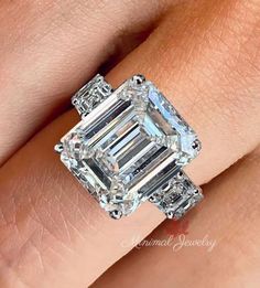 a woman's engagement ring with an emerald cut diamond