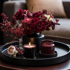 a tray with candles and flowers on it