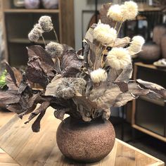 a vase filled with flowers on top of a wooden table