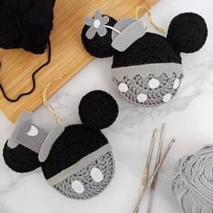 crocheted mickey mouse ornament next to yarn and knitting needles on a table